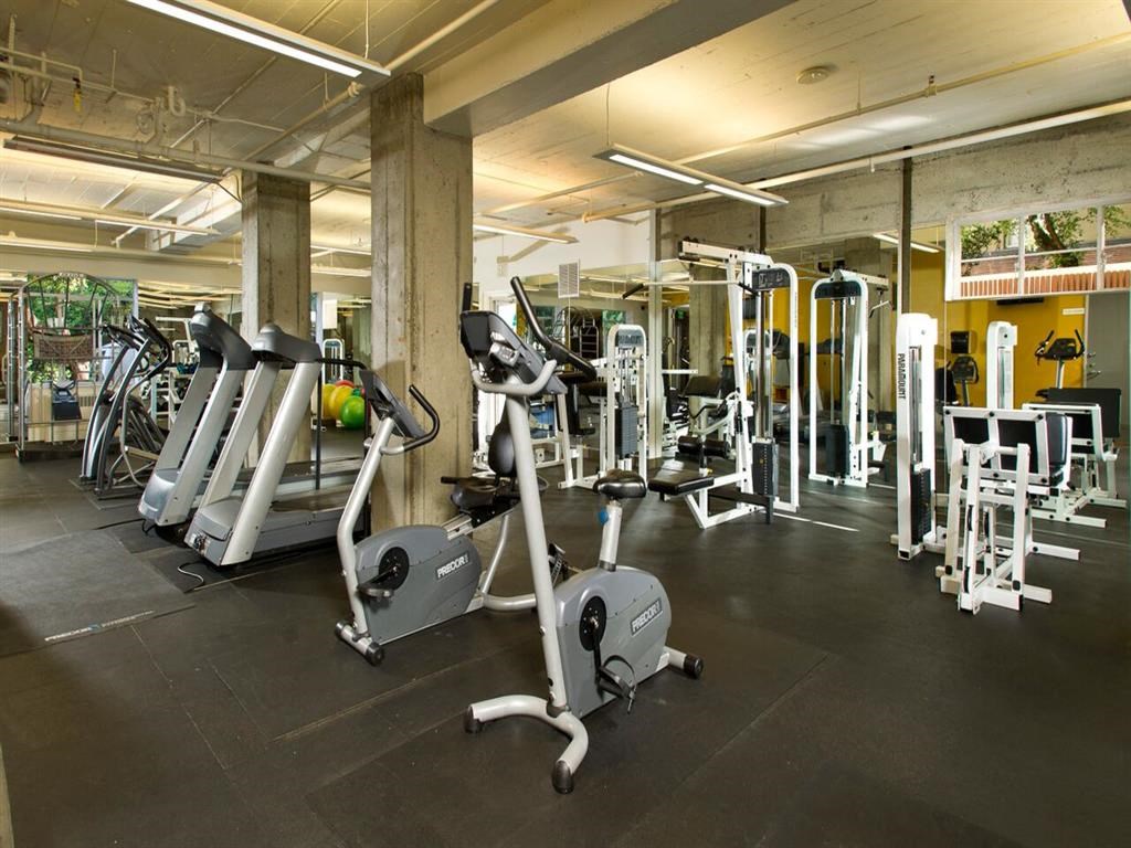 a gym with weights and cardio equipment in a parking garage