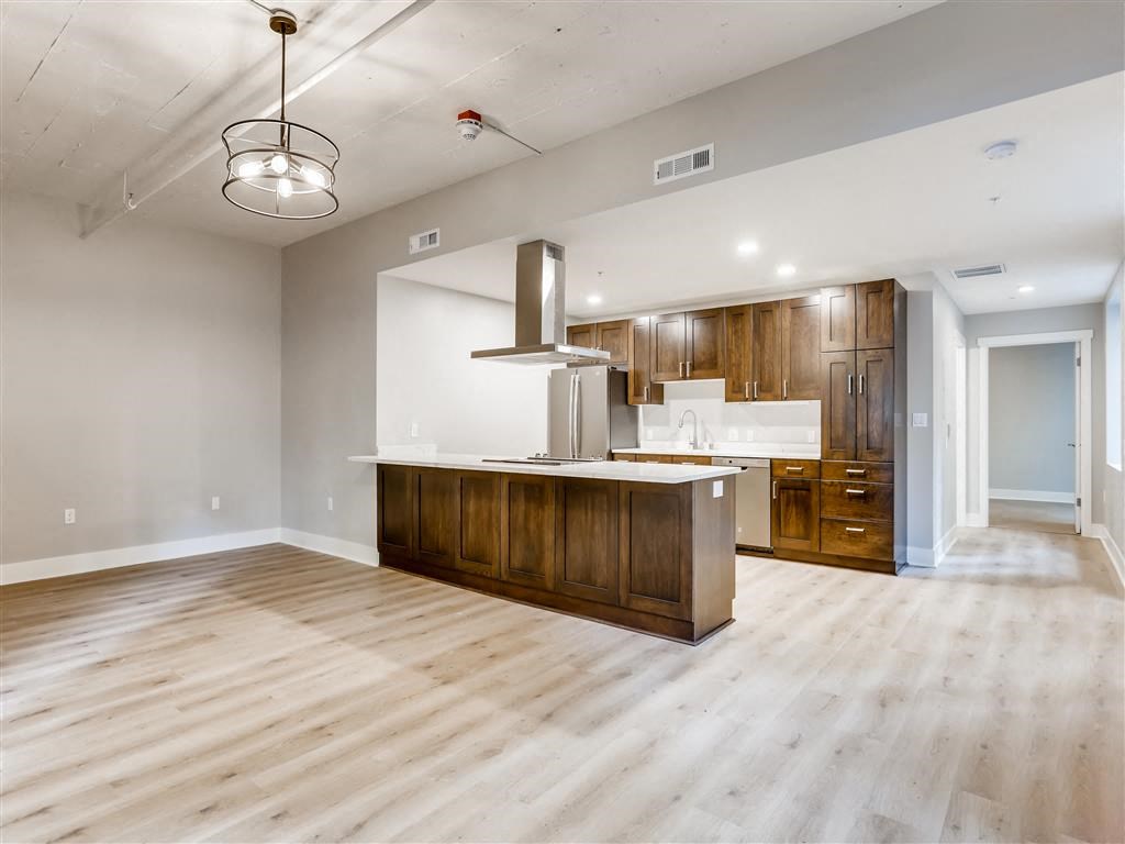 an empty kitchen and living room with wood flooring