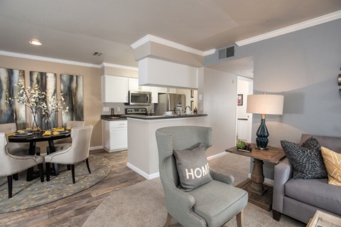 A living room with a grey couch and a grey armchair with the word HOME on it.