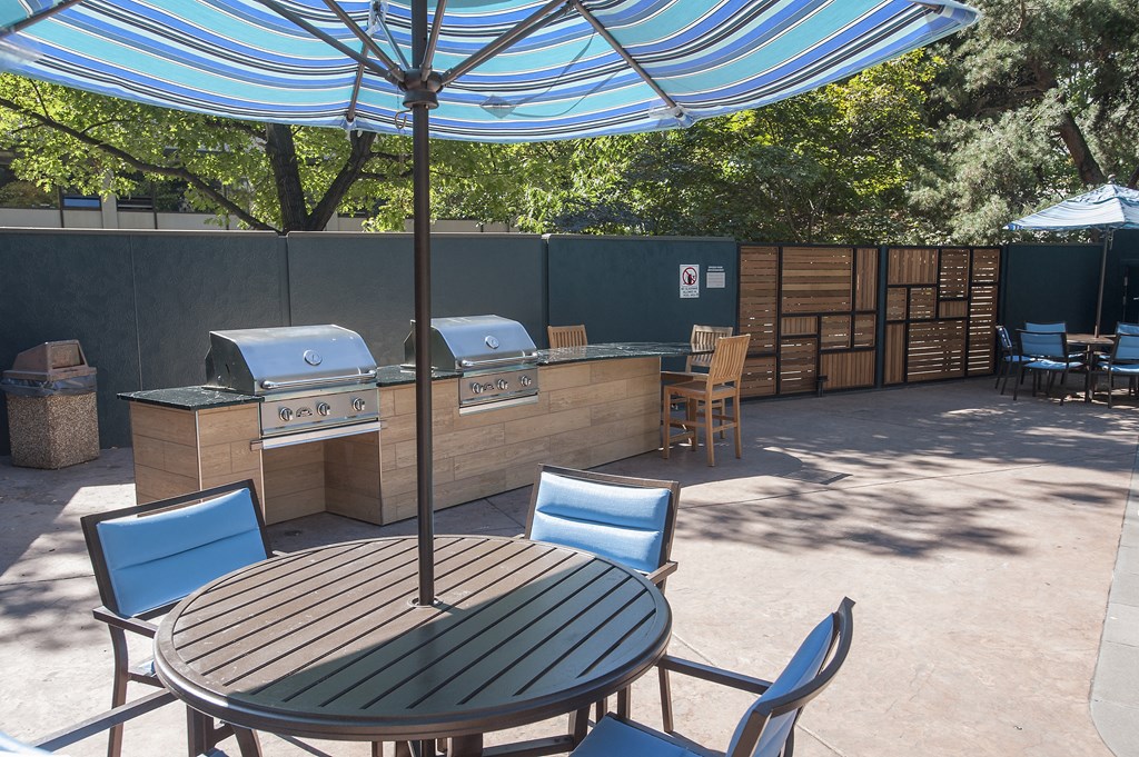 a patio with an umbrella and a table with chairs