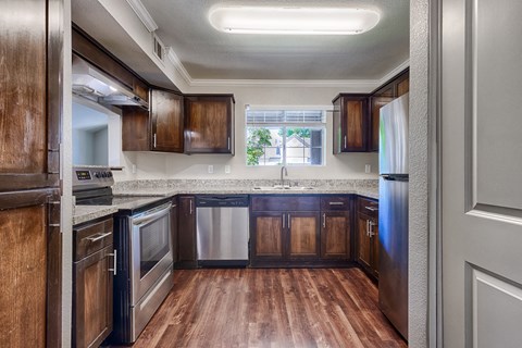 A kitchen with dark wood cabinets and stainless steel appliances.