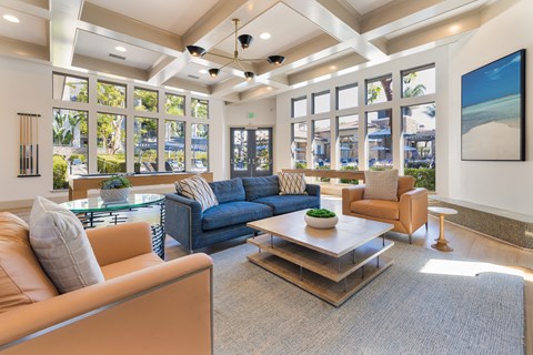 A living room with a blue couch and a brown armchair.