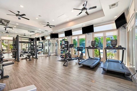 A gym with treadmills, weights, and exercise equipment.