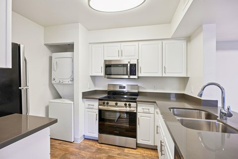 A kitchen with white cabinets and stainless steel appliances.