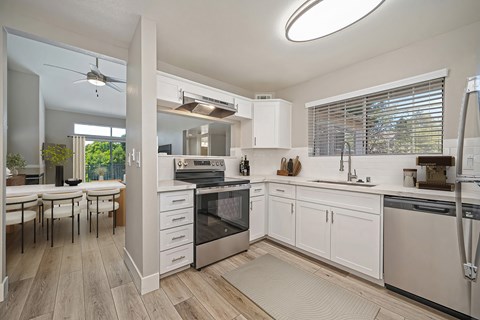A modern kitchen with white cabinets and stainless steel appliances.