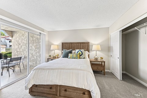 a bedroom with a bed and a sliding glass door to a patio