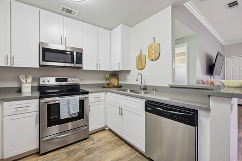 A kitchen with white cabinets and stainless steel appliances.