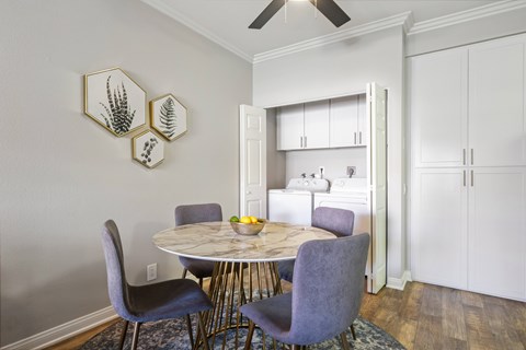 A dining room with a table and chairs.