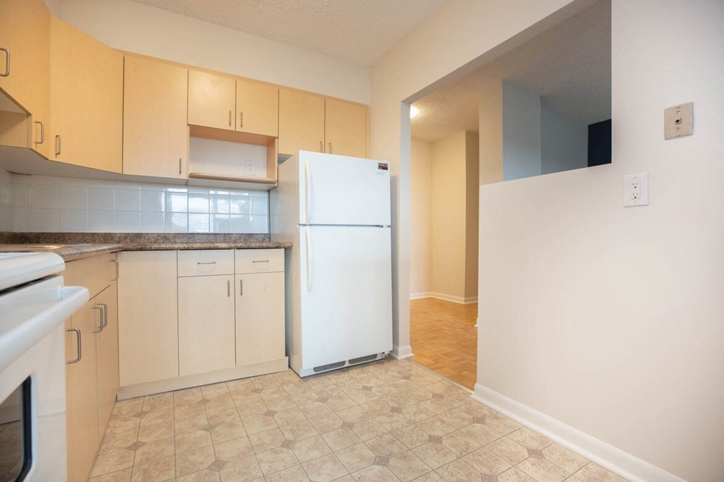 a kitchen with a white refrigerator and white cabinets
