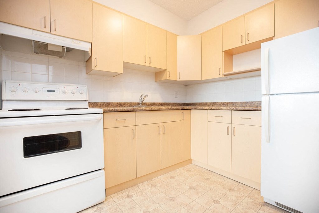 a kitchen with white appliances and ivory cabinets