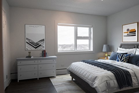 A bedroom with a large bed and a dresser with a mirror.