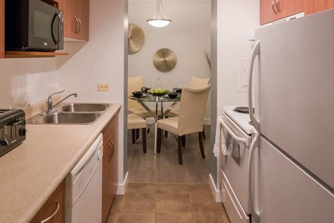 A kitchen with a table and chairs in the middle.