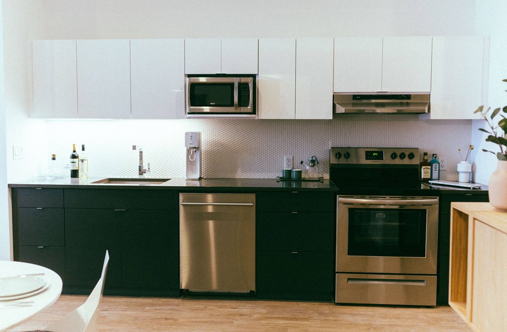 a kitchen with green cabinets and stainless steel appliances