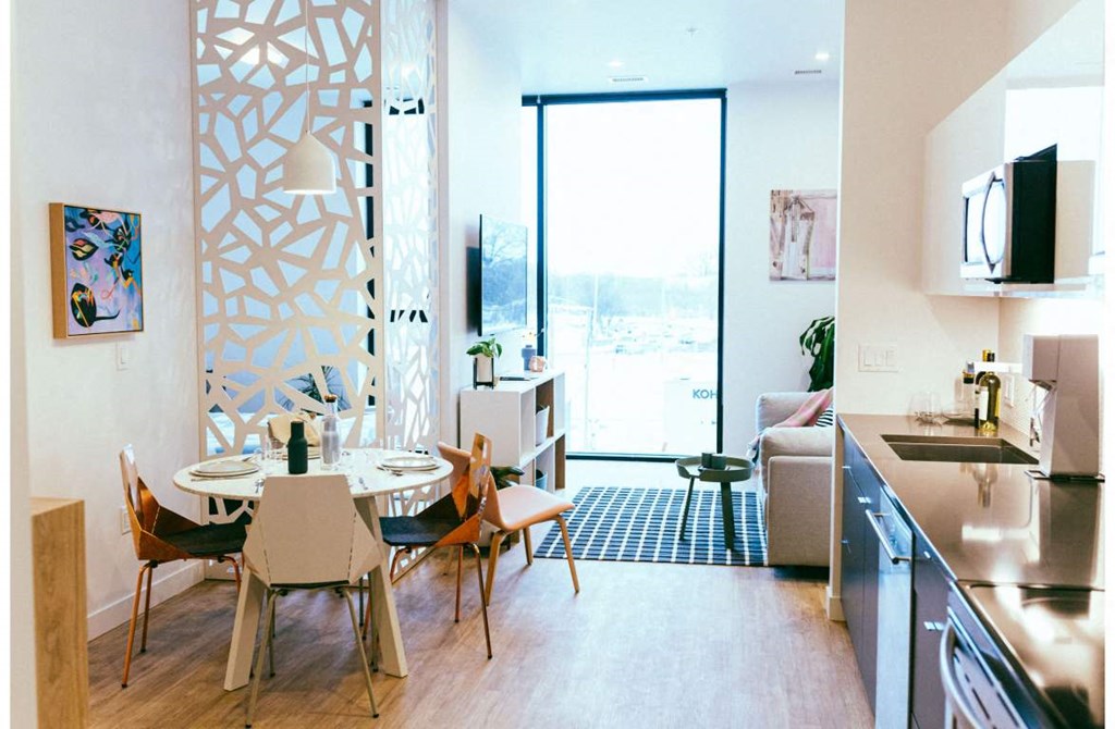 a living room and kitchen with a table and chairs