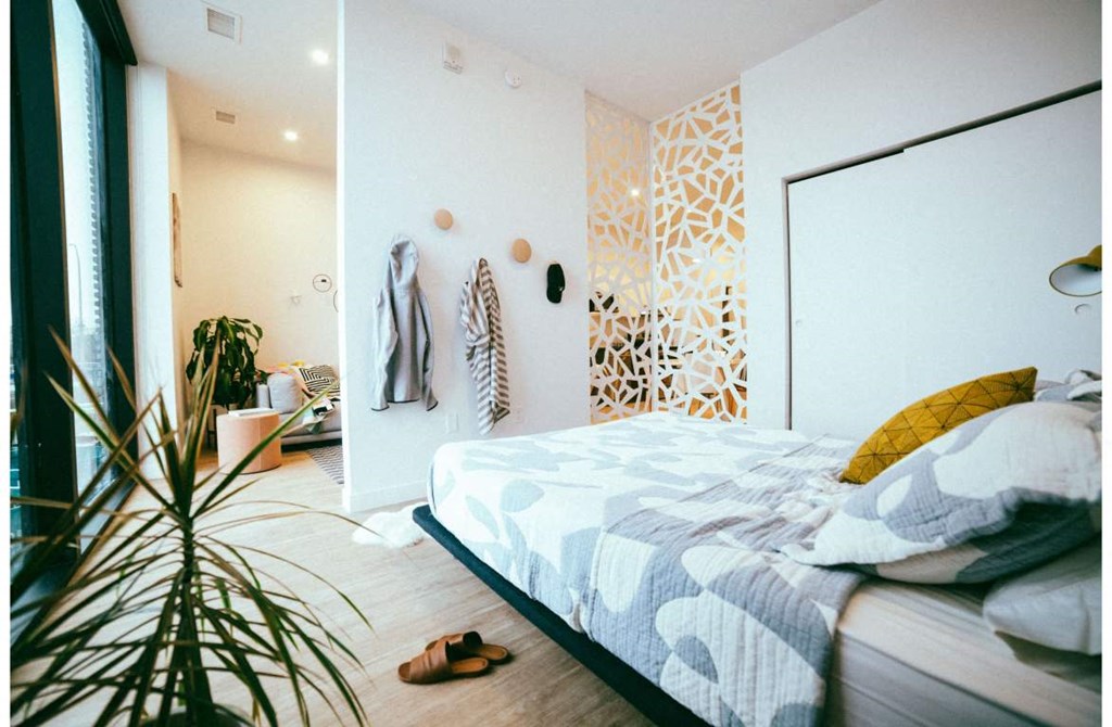 a bedroom with a bed and a plant