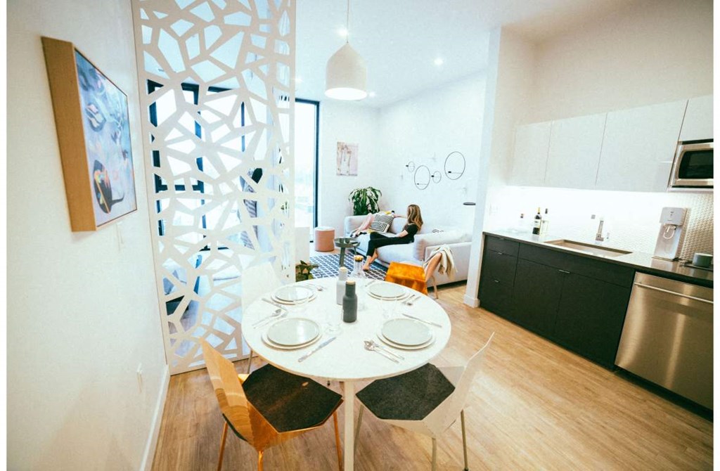 a dining room and kitchen with a white table and chairs