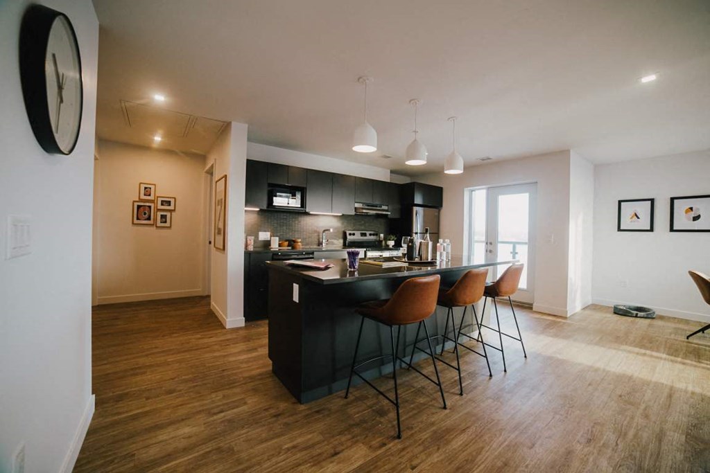 a kitchen with a bar and chairs in a room