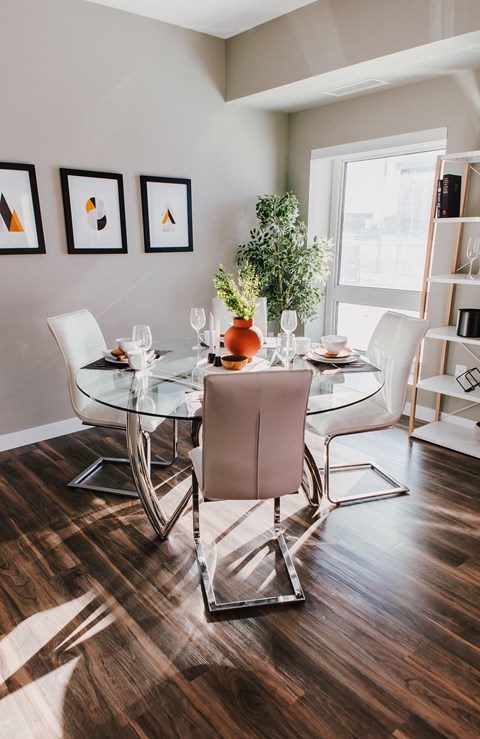 a dining room with a glass table and chairs