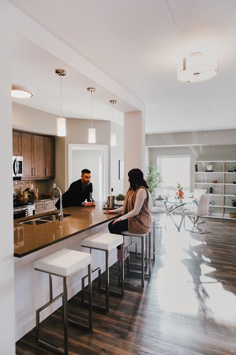 a man and woman sitting at a counter in a kitchen