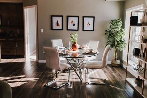a dining room with a glass table and chairs