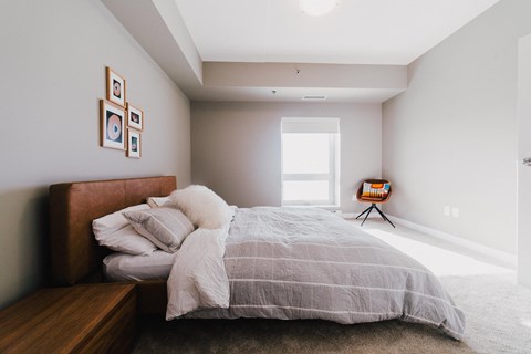 a bedroom with a bed and a large window
