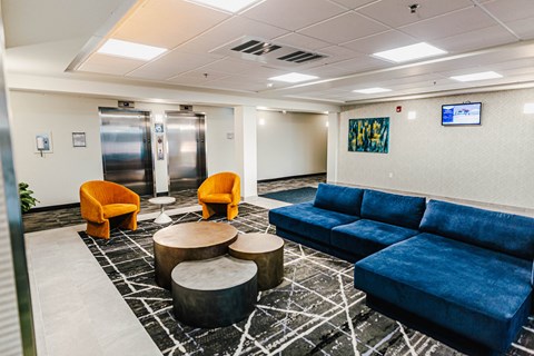 a lobby with blue couches and chairs and tables