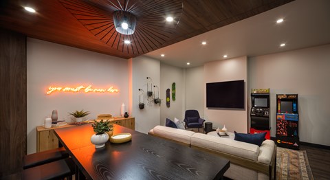 A modern living room with a wooden ceiling and a neon sign that says "your best friend".