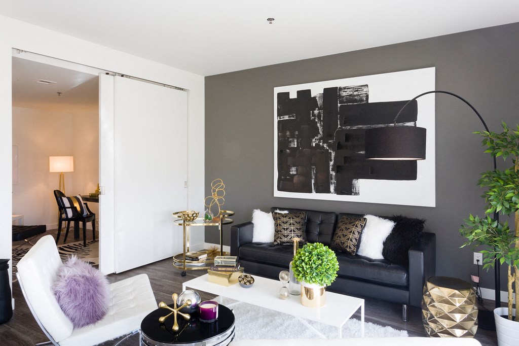 a living room with a black couch and a white coffee table
