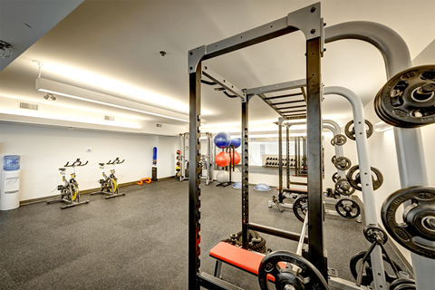 a gym with exercise equipment and bikes in a building