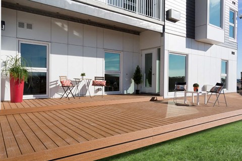 a large wooden deck in front of a white house