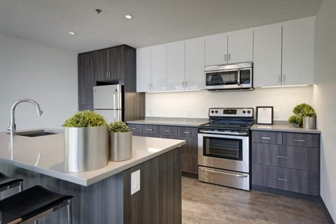 a modern kitchen with stainless steel appliances and white cabinets