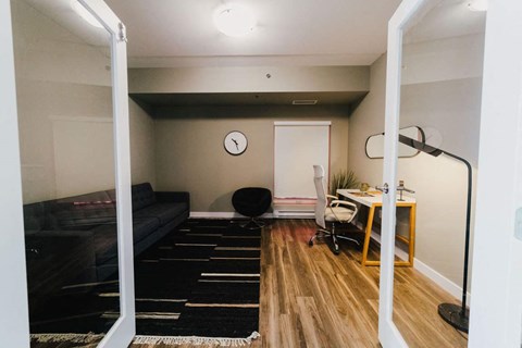 a den with a couch and a desk