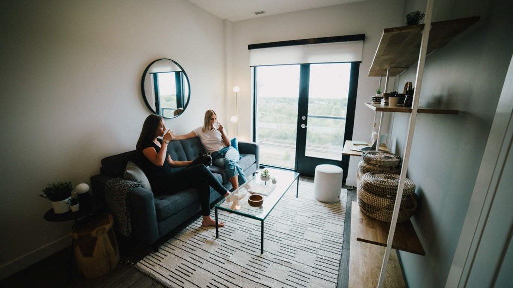two women sitting on a couch in a living room