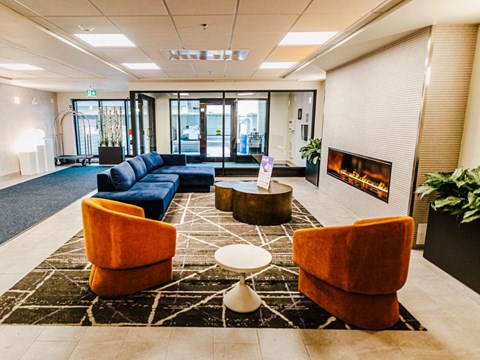 a lobby with couches and chairs and a fireplace