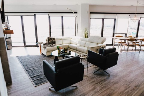 a living room with a white couch and two black chairs