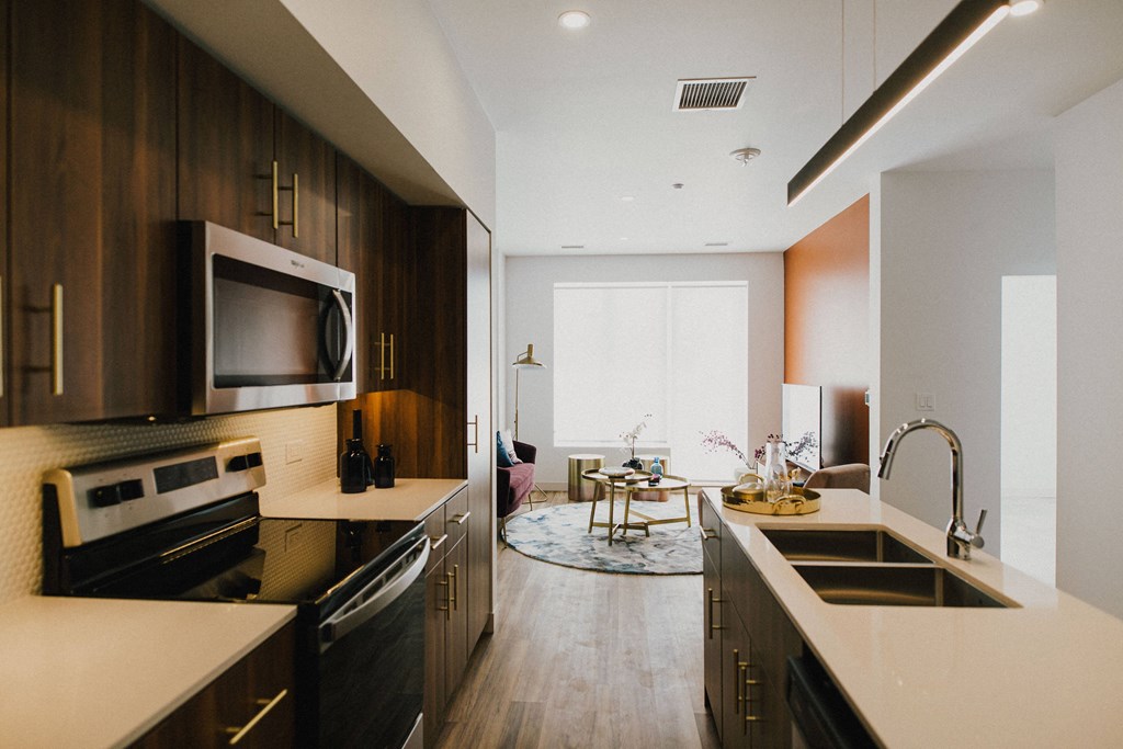 A modern kitchen with dark wood cabinets and stainless steel appliances.