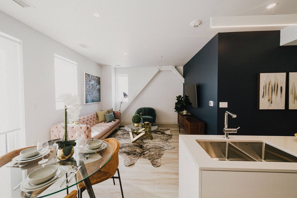 a living room and dining room with a sink and a table