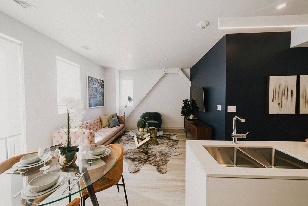A modern kitchen with a dining table set for two.
