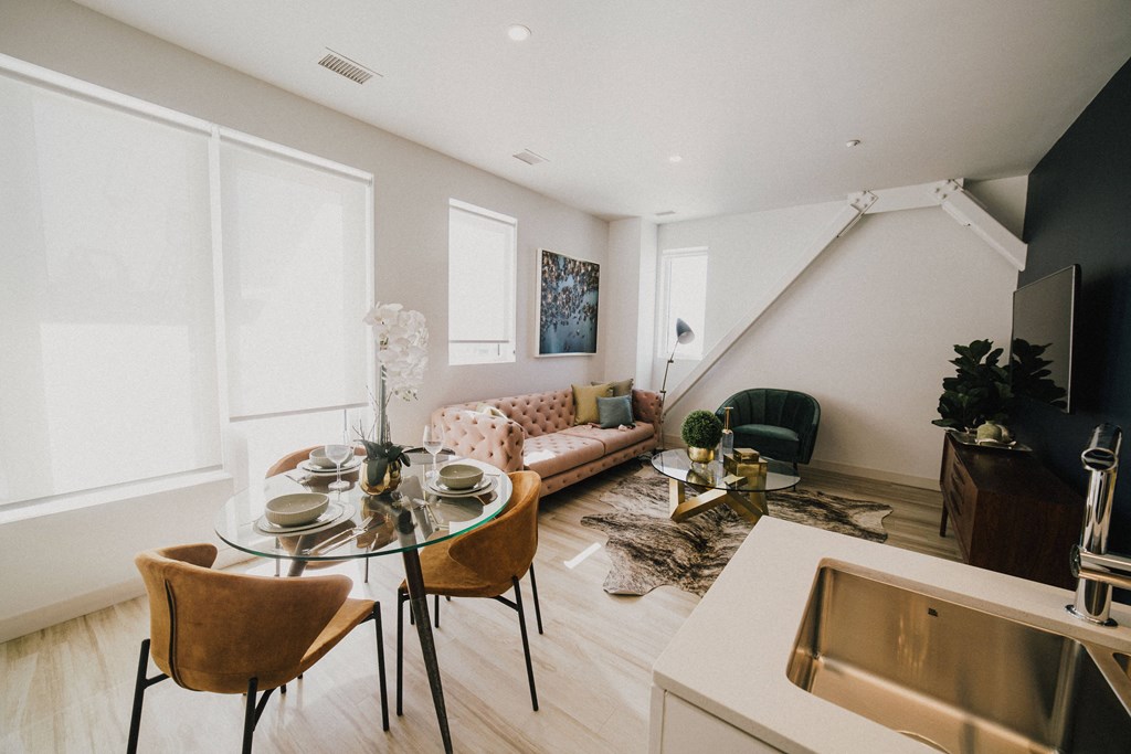 a living room and dining room with a table and chairs