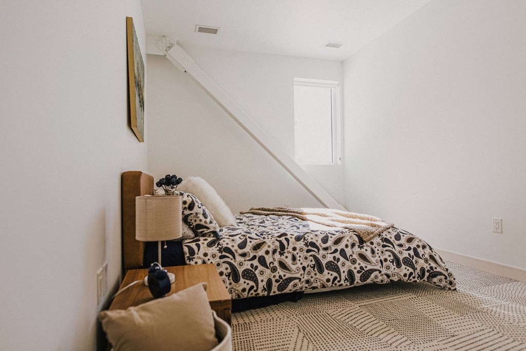 a bedroom with a bed next to a staircase