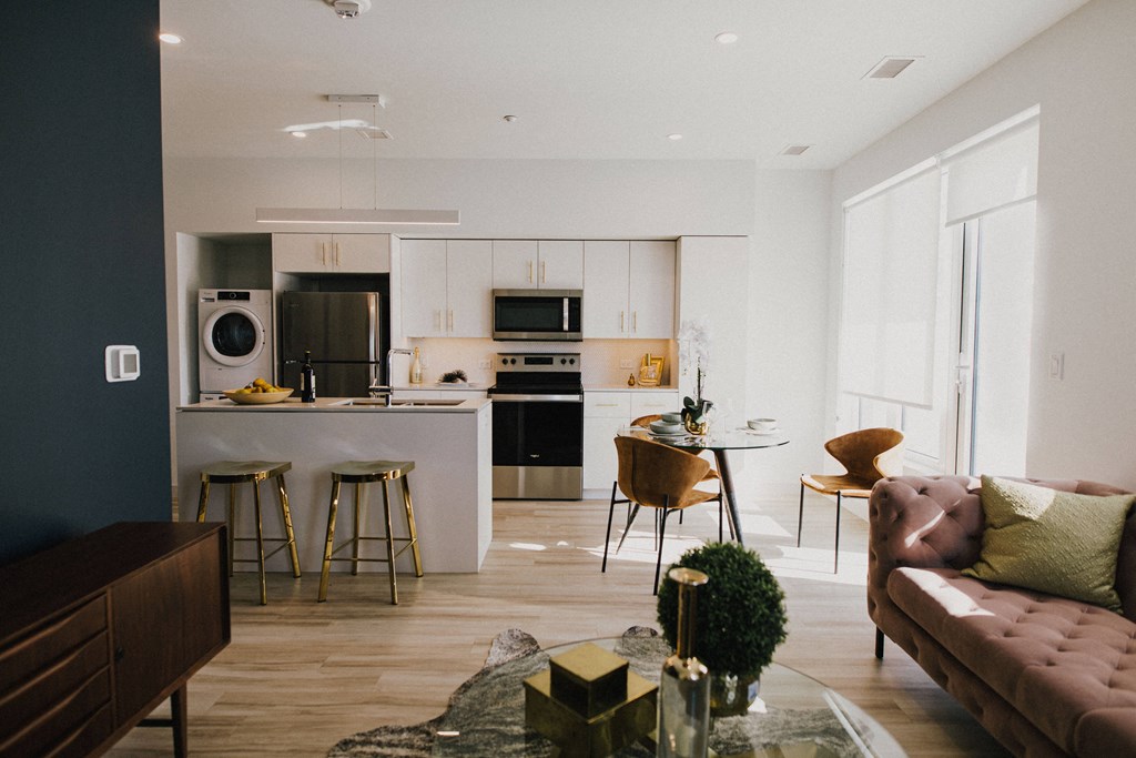 a living room with a kitchen and a table with chairs