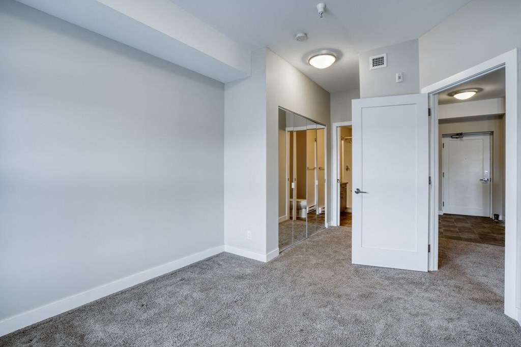 a bedroom with a closet and a door to a bathroom