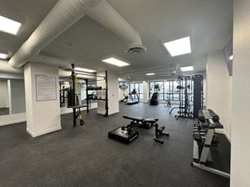a large fitness room with weights and other exercise equipment