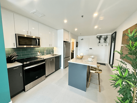 a kitchen with an island and a stove and a refrigerator
