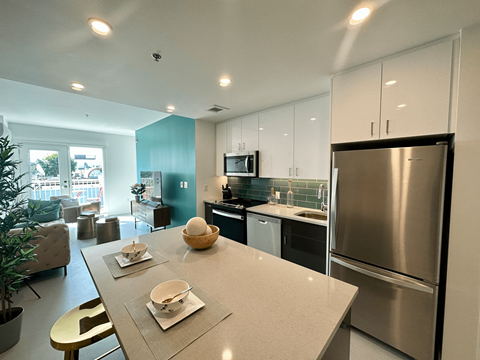 a kitchen and living room with stainless steel appliances and a table