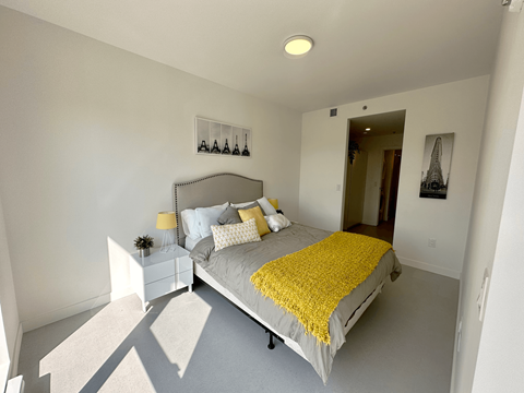 a bedroom with a large bed and a yellow blanket