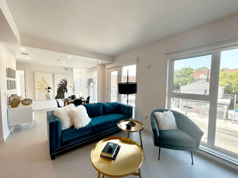 A living room with a blue couch and a gold coffee table.