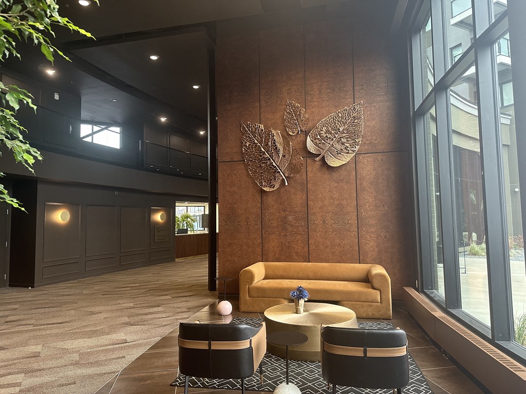 A room with a brown sofa and a wall decoration of butterflies.