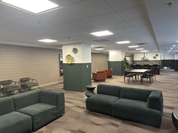A conference room with a green couch and a table.
