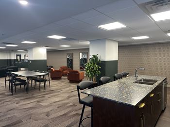 A room with a kitchenette and a dining table.